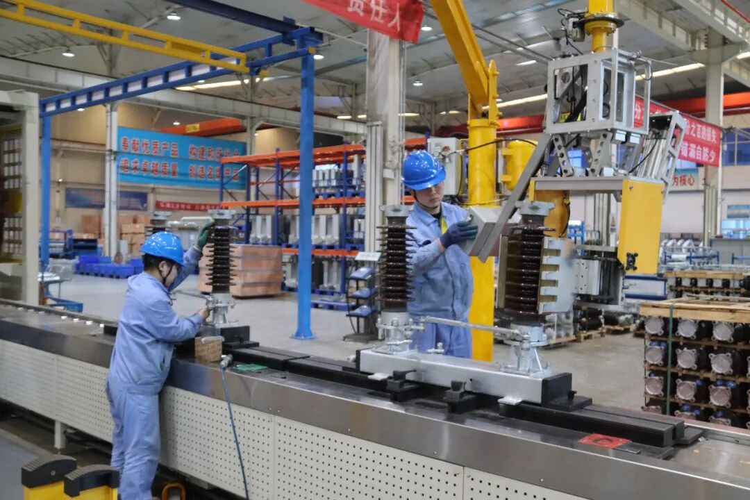 山东生产车间工人配合吊装设备组装高压电气部件